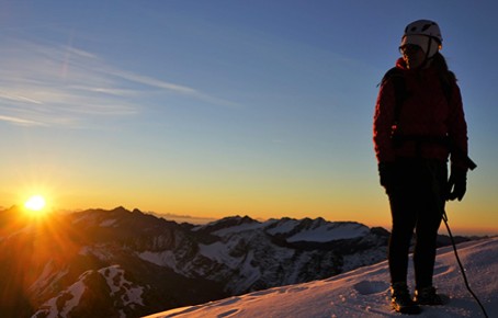 Rifugio Coston: Rifugio a Solda, in Alto Adige. Una persona con l'equipaggiamento da montagna sull'Ortles coperto di neve con il sorgere del sole sullo sfondo.