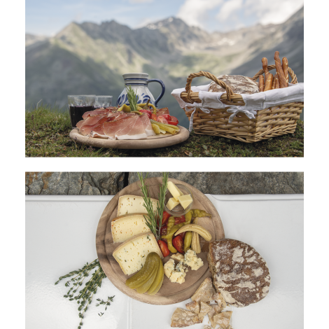 Un piatto di speck e un piatto di formaggio con pane e vino per ristorarsi.