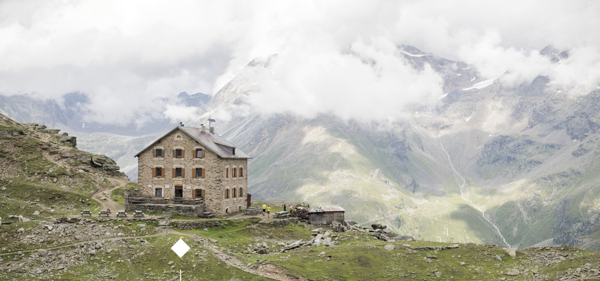Il rifugio Coston in mezzo a un mare di nuvole.